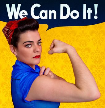 Beautiful young woman posing as working girl and representing the ideals of the original poster of Rosie the Riveter, year 1943