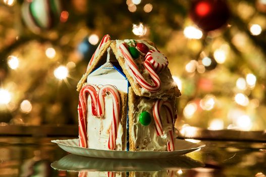 Gingerbread house against a background of christmas tree lights