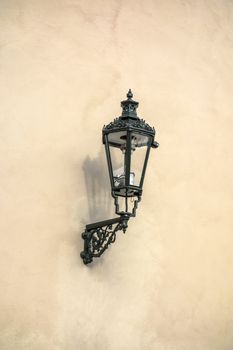 Old street light closeup on stone wall in Prague