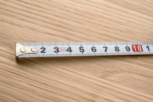 Tape measure closeup on wood background 