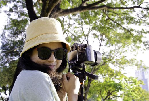 Beautiful smiling girl with camera on nature. 