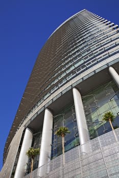 Perspective and underside angle view of modern glass building skyscrapers over blue sky 