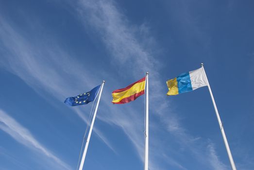 The Flags of the European Union,Spain and the Canary Islands under a blue sky
