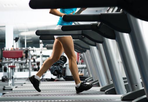 woman running on a treadmill in a fitness club, sport in the fitness club