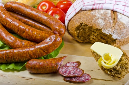 Tasty Polish sausage with bread, butter and vegetables