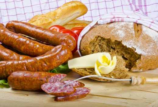 Tasty Polish sausage with bread, butter and vegetables