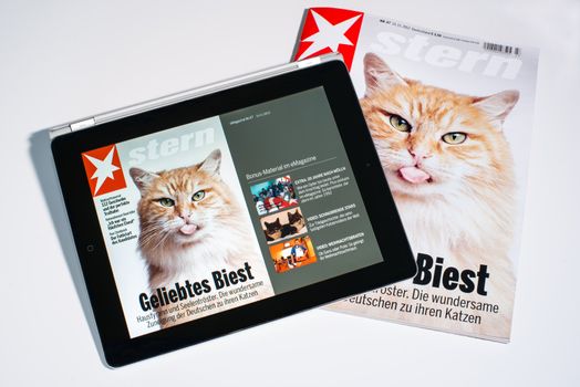STUTTGART - NOVEMBER 18, 2012: The latest Stern e-Magazine is opened on an Apple iPad next to the printed version on November 18, 2012 in Stuttgart, Germany. Stern offers additional contents such as video interviews in addition to their weekly print-magazine.