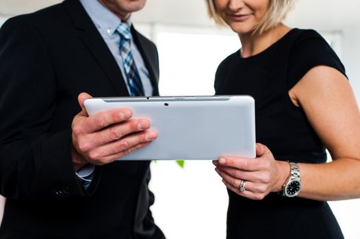 Boss and secretary posing with a tablet device, cropped image.