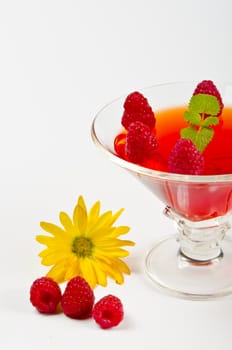 Fruit jelly in the glass bowls with fresh raspberries