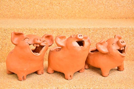 Three Pig statues laugh facing the same way.
