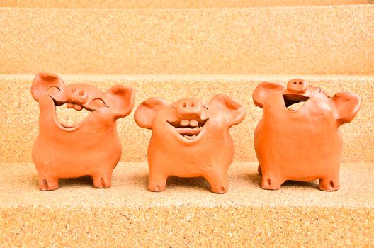 Three Pig statues laugh