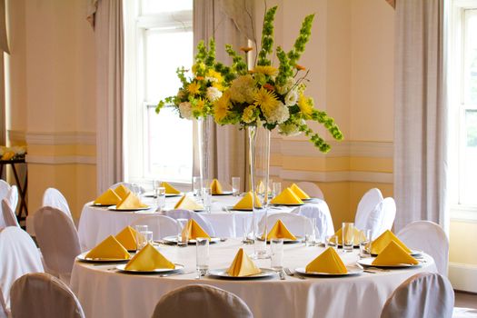 Place settings, tables, and chairs are empty before the guests arrive at a wedding reception.