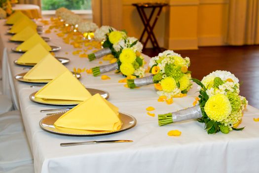 Place settings, tables, and chairs are empty before the guests arrive at a wedding reception.