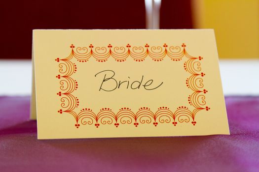 This name tag says bride to reserve her spot at a wedding dinner table.