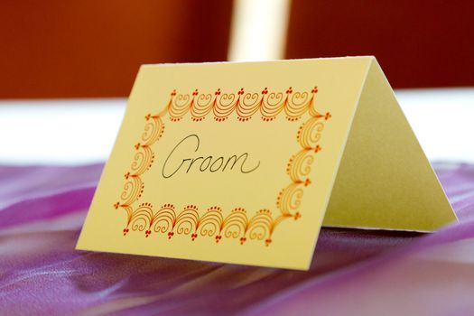 This name tag at a wedding says "groom" to reserve his spot at a table.