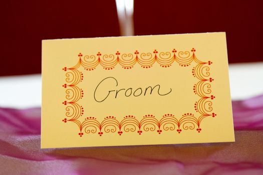 This name tag at a wedding says "groom" to reserve his spot at a table.