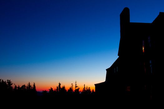 Timberline Lodge on Mount Hood in Oregon is photographed from the side at dusk during a nice sunset.