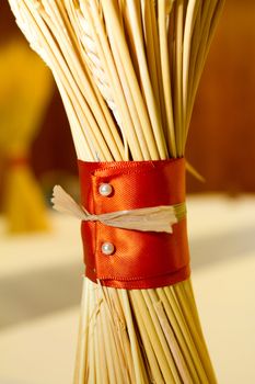 A bundle of wheat is wrapped and used for decor at a harvest style wedding.