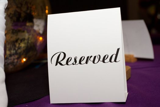 This piece of paper has the word reserved written on it in type letters to indicate for guests not to sit here.