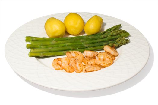 a plate with asparagus, shrimps and potatoes isolated on a white background