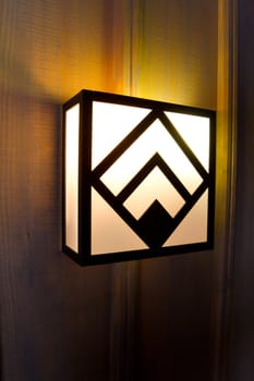 Historic Timberline lodge light fixtures on an old wooden wall in a hallway.