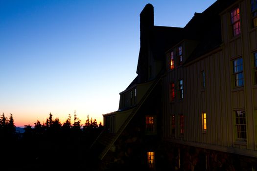 Timberline Lodge on Mount Hood in Oregon is photographed from the side at dusk during a nice sunset.