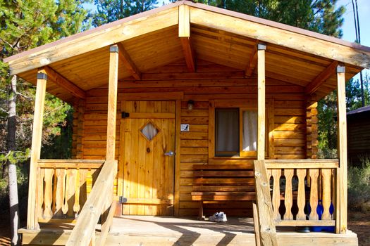 A rustic log cabin lodge building in the woods at an outdoors camping park facility.