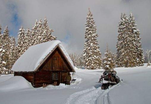 A small, wooden, snow-covered cottage in winter