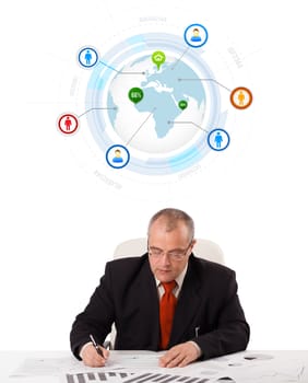 businessman sitting at desk with a globe and social icons, isolated on white