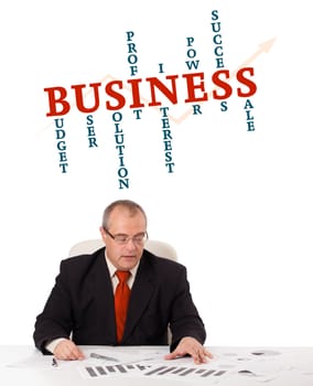 businessman sitting at desk with word cloud, isolated on white