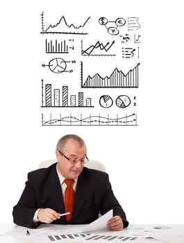 businessman sitting at desk with statistics and graphs, isolated on white