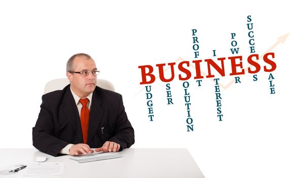 businessman sitting at desk and typing on keyboard with word cloud, isolated on white