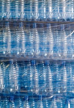 Plastic wrapping over finished water bottles in factory, warehouse industry