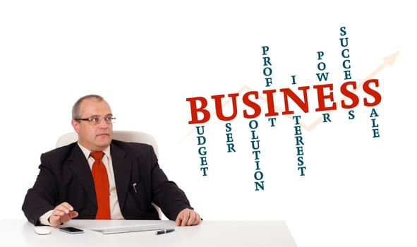 businesman sitting at desk with business word cloud, isolated on white