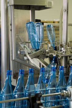 Plastic water bottles on conveyor or water bottling machine industry