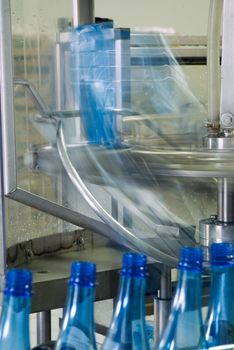Plastic water bottles on conveyor or water bottling machine industry with motion blur