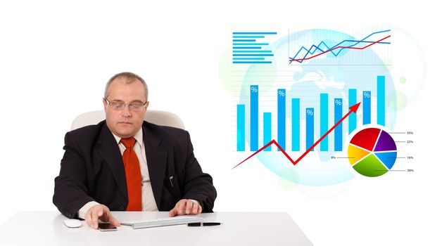 Businessman sitting at desk with statistics, isolated on white