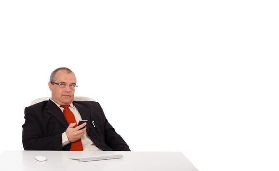 businessman sitting at desk and holding a mobilephone with copys pace, isolated on white