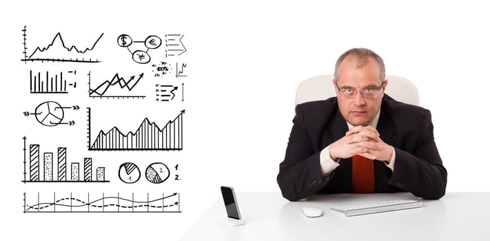 Businessman sitting at desk with diagrams and graphs, isolated on white