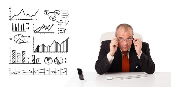 Businessman sitting at desk with diagrams and graphs, isolated on white