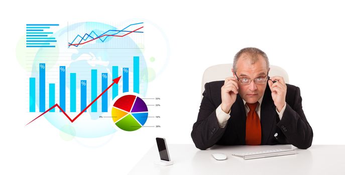 Businessman sitting at desk with statistics, isolated on white