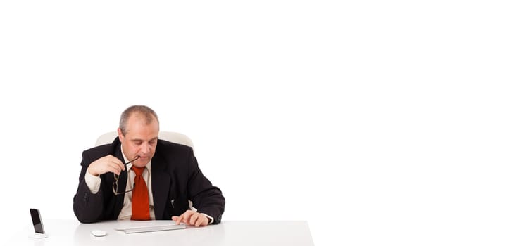businessman sitting at desk and typing on keyboard with copy scape, isolated on white