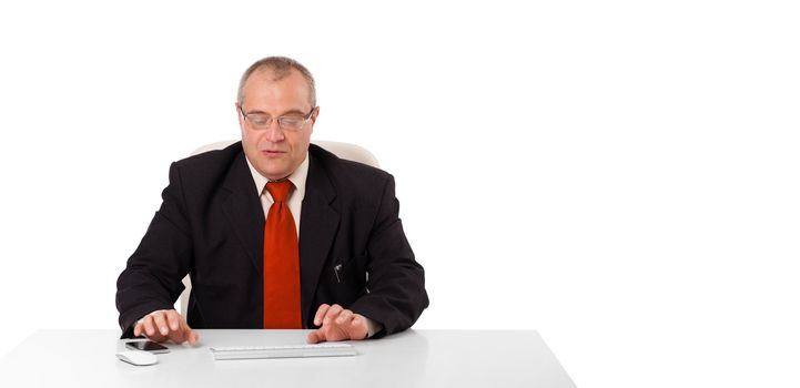 businessman sitting at desk and typing on keyboard with copy scape, isolated on white