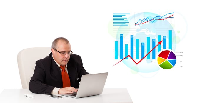 Businessman sitting at desk with laptop and statistics, isolated on white