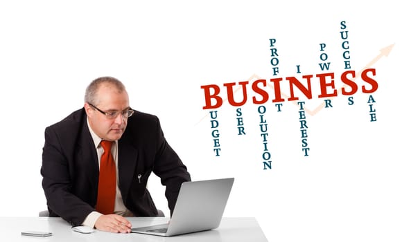 bisinessman sitting at desk and looking laptop with business word cloud, isolated on white