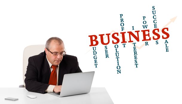 bisinessman sitting at desk and looking laptop with business word cloud, isolated on white