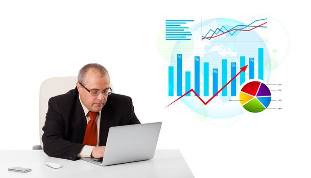 Businessman sitting at desk with laptop and statistics, isolated on white