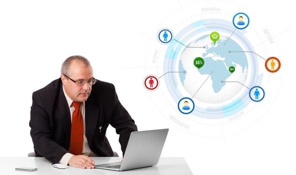 businessman sitting at desk and looking laptop with globe and social icons, isolated on white
