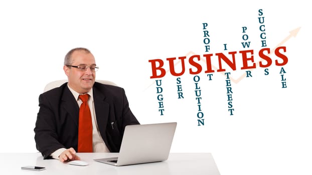 bisinessman sitting at desk and looking laptop with business word cloud, isolated on white