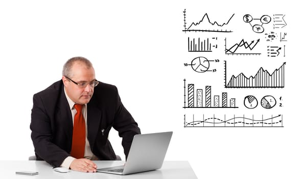 Businessman sitting at desk with diagrams and laptop, isolated on white